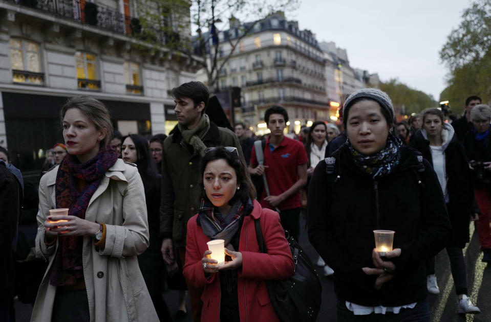 People walk toward the Notre Dame Cathedral to attend a vigil, in Paris, Tuesday April 16, 2019. Firefighters declared success Tuesday in a more than 12-hour battle to extinguish an inferno engulfing Paris' iconic Notre Dame cathedral that claimed its spire and roof, but spared its bell towers and the purported Crown of Christ. (AP Photo/Kamil Zihnioglu)