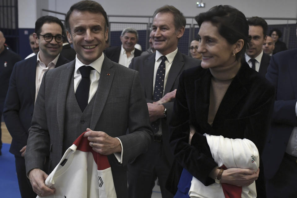 French President Emmanuel Macron, left and French Sports Minister Amelie Oudea-Castera visit France's National Institute of Sport, Expertise, and Performance (INSEP), prior to the president presenting his New Year's wishes to elite athletes ahead of the Paris 2024 Olympic and Paralympic Games, in Paris, Tuesday, Jan. 23, 2024. (Stephane De Sakutin/Pool Photo via AP)