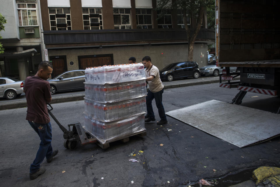 Workers move bottled water to be sold at a supermarket in the Copacabana neighborhood of Rio de Janeiro, Brazil, Wednesday, Jan. 15, 2020. There’s a creeping sense of alarm in Rio de Janeiro after more than a week of foul tasting and smelling tap water in dozens of neighborhoods, and residents are hoarding bottled water. (AP Photo/Bruna Prado)