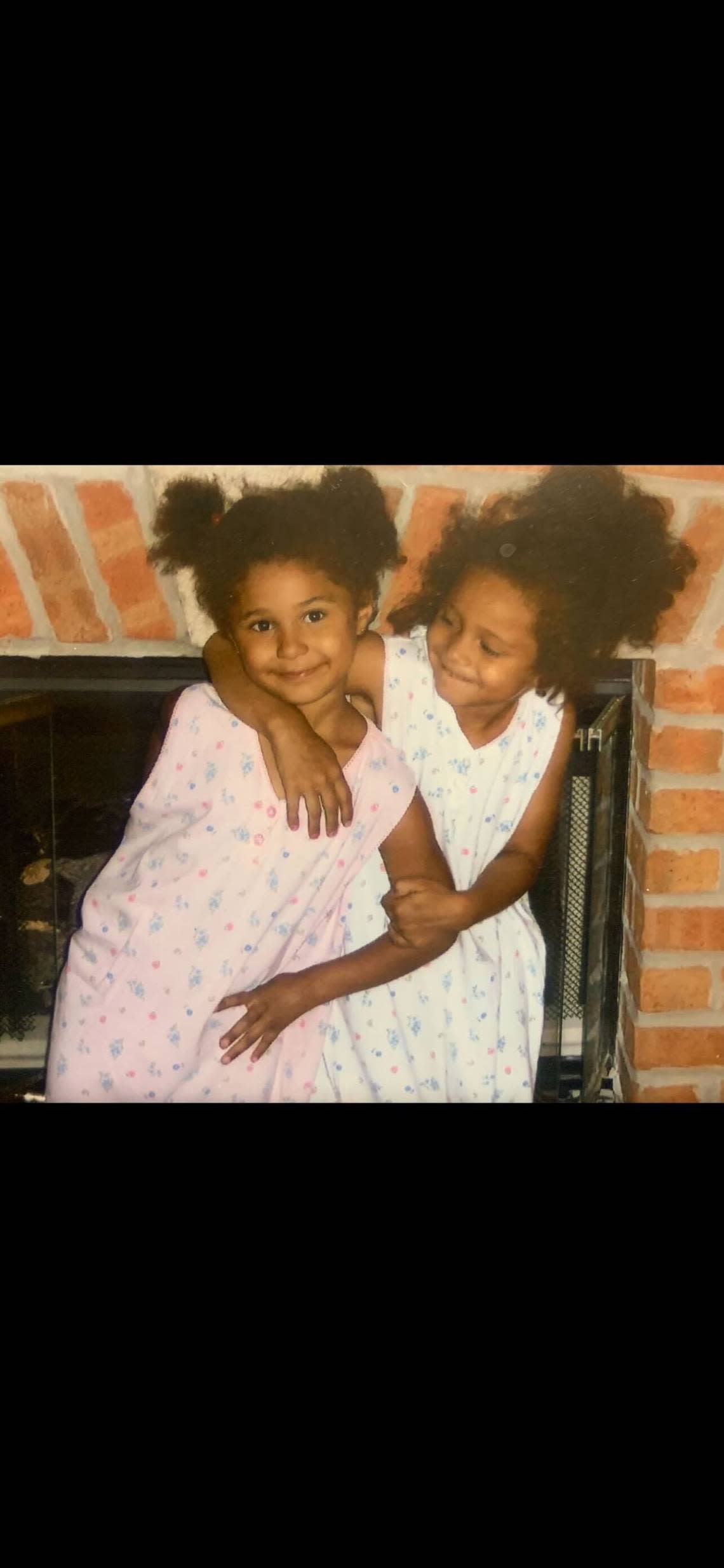 Shayla (left) and Sydnee (right) pose wearing matching gowns. The girls were always dressed alike as children.