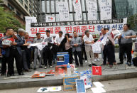 South Korean small and medium-sized business owners use scissors to cut t-shirts from Japanese brands during a rally calling for a boycott of Japanese products in front of the Japanese embassy in Seoul, South Korea, Monday, July 15, 2019. South Korea and Japan last Friday, July 12, failed to immediately resolve their dispute over Japanese export restrictions that could hurt South Korean technology companies, as Seoul called for an investigation by the United Nations or another international body. The signs read: "Our supermarket does not sell Japanese products." (AP Photo/Ahn Young-joon)