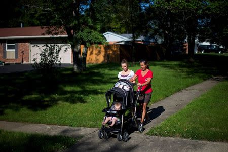 Heather Padgett, with her mother Debi Padgett (R), takes her daughters Kinsley and Kiley for a walk outside their home in Cincinnati, Ohio July 16, 2015. REUTERS/Aaron P. Bernstein