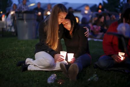 Heidi Wickersham (L), 31, comforts her sister Gwendoline Wickersham, 28, during a candlelight vigil for victims of the Umpqua Community College shooting in Winston, Oregon, United States, October 3, 2015. REUTERS/Lucy Nicholson