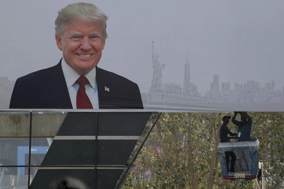 Indian workers fix a billboard at an entrance of Sardar Patel stadium ahead of the visit of U.S. President Donald Trump in Ahmedabad, India, Sunday, Feb. 23, 2020. Trump is visiting the city in Gujarat during a two-day trip to India to attend an event called "Namaste Trump," which translates to "Greetings, Trump," at a cricket stadium along the lines of a "Howdy Modi" rally attended by Indian Prime Minister Narendra Modi in Houston last September. (AP Photo/Ajit Solanki)