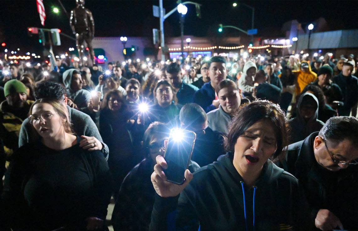 The crowd holds up their lit phones as the community gathers for a vigil in Veterans Park for slain Selma officer Gonzalo Carrasco Jr. Thursday, Feb 2, 2023 in Selma.