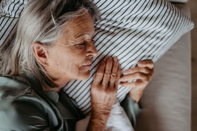 Top view of senior woman, resting with closed eyes.