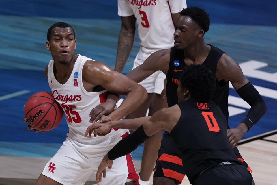 Houston forward Fabian White Jr. grabs a rebound in front of Oregon State forward Warith Alatishe, right, and guard Gianni Hunt (0) during the second half of an Elite 8 game in the NCAA men's college basketball tournament at Lucas Oil Stadium, Monday, March 29, 2021, in Indianapolis. (AP Photo/Michael Conroy)