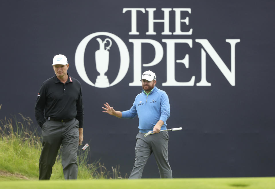 J.B. Holmes of the United States, right acknowledges the crowd as he completes his second round of the British Open Golf Championships, with South Africa's Ernie Els looking on, at Royal Portrush in Northern Ireland, Friday, July 19, 2019.(AP Photo/Jon Super)