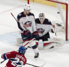 Montreal Canadiens' Cole Caufield (22) scores against Columbus Blue Jackets goaltender Elvis Merzlikins (90) and Jack Roslovic (96) during overtime NHL hockey game action in Montreal, Thursday, Oct. 26, 2023. (Christinne Muschi/The Canadian Press via AP)