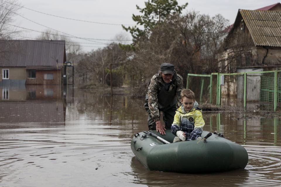 A man pushes an inflatable boat with a boy in a flooded area in Orenburg, Russia, Wednesday, April 10, 2024. Russian officials are scrambling to help homeowners displaced by floods, as water levels have risen in the Ural River. The floods in the Orenburg region near Russia's border with Kazakhstan sparked the evacuation of thousands of people following the collapse of a dam on Saturday. (AP Photo)