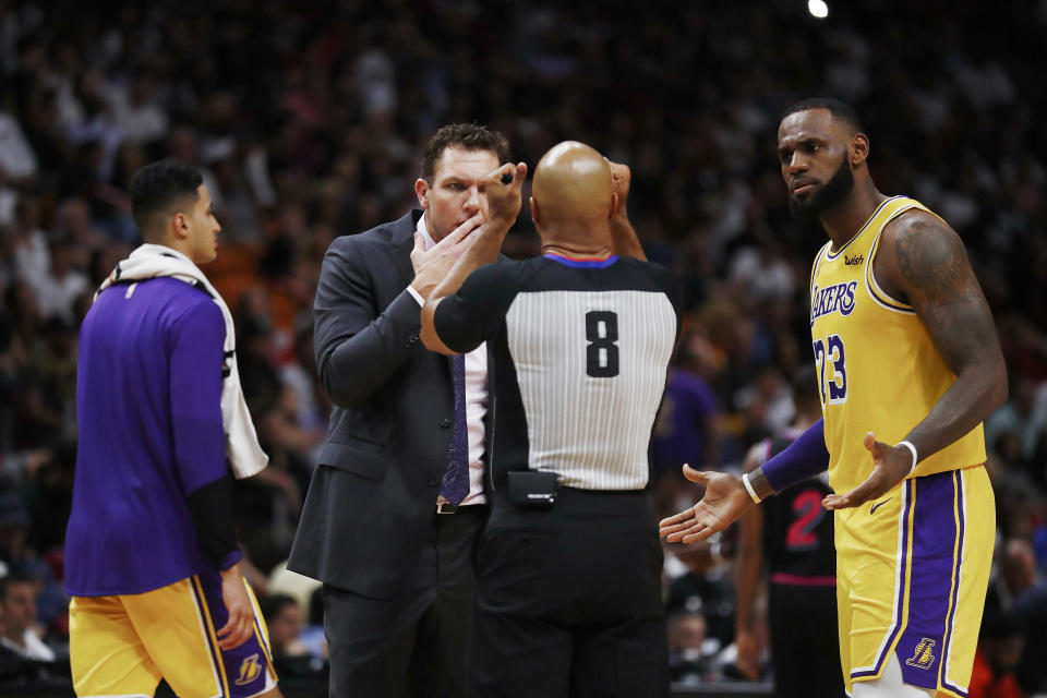 Los Angeles Lakers coach Luke Walton, center, and forward LeBron James, right, question a referee during the second half of the team's NBA basketball game against Miami Heat, Sunday, Nov. 18, 2018, in Miami. (AP Photo/Brynn Anderson)