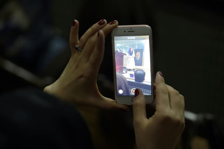 An Afghan woman records footage on her mobile phone at the first public event for the "Where Is My Name" campaign in Kabul