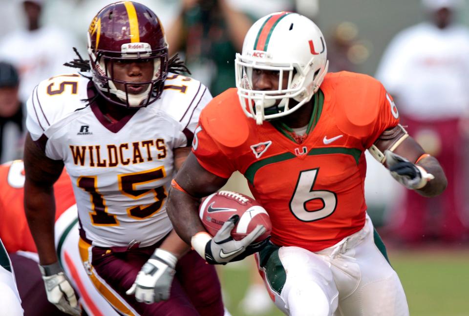 Miami's Lamar Miller (6) runs the ball with pressure from Bethune-Cookman's Ryan Lewis (15) in the first half of an NCAA college football game in Miami, on Saturday, Oct. 1, 2011.