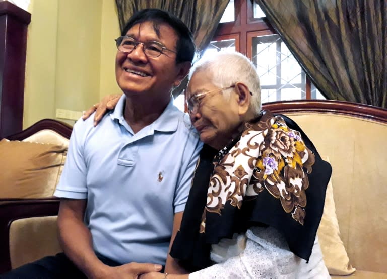 Freed after more than a year in prison, Cambodian opposition leader Kem Sokha sits with his mother