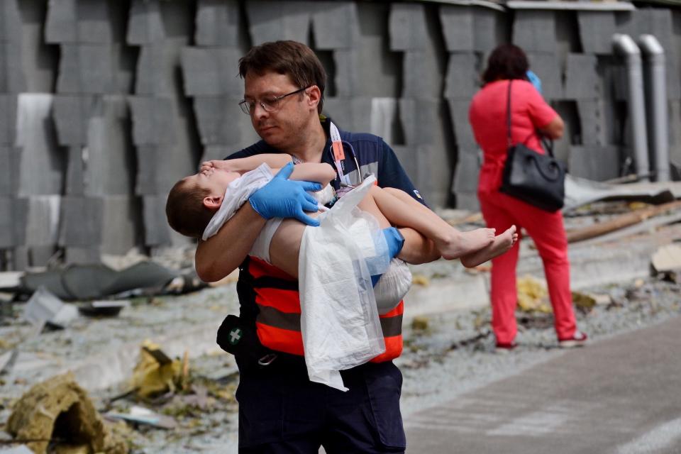 A doctor carries a child