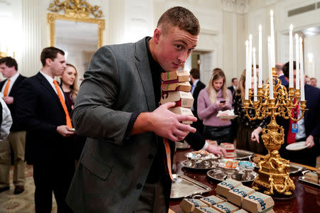 A Clemson player carries fast food hamburgers provided due to the partial government shutdown as the 2018 College Football Playoff National Champion Clemson Tigers are welcomed in the State Dining Room of the White House in Washington, U.S., January 14, 2019. REUTERS/Joshua Roberts