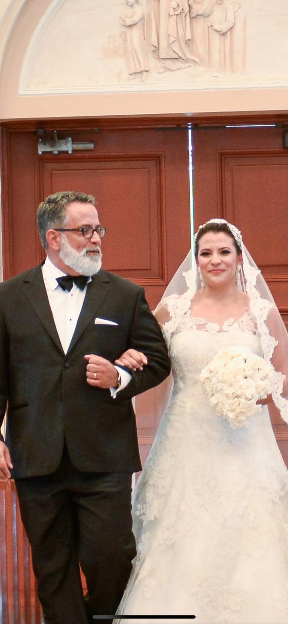 Jorge Mursuli walks his niece Evy Marie Pereira down the aisle.