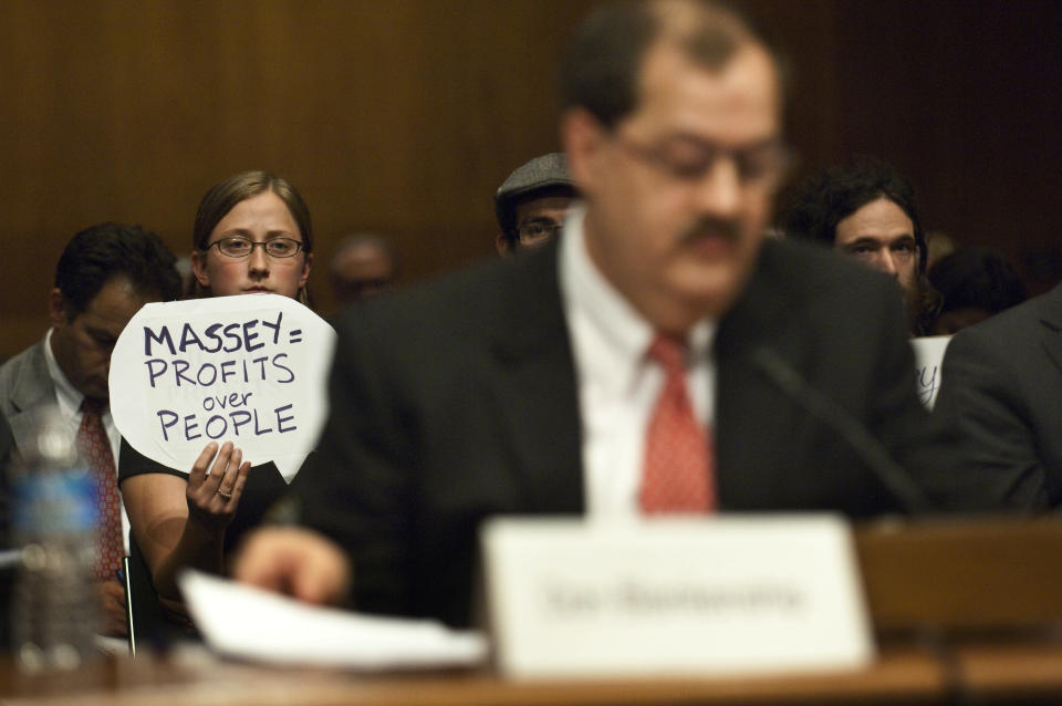 A protester holds a sign behind Don Blankenship, who had been chairman and CEO of Massey Energy Co. until a deadly explosion at one of his mines killed 29 people. (Photo: Scott J. Ferrell via Getty Images)