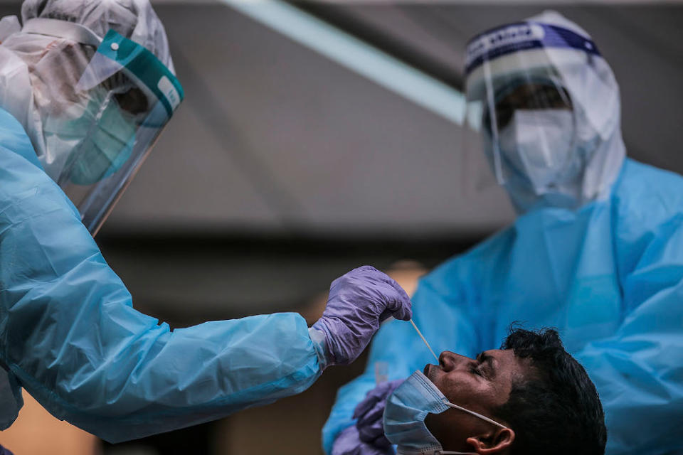 Health workers conduct a Covid-19 screening test on local and foreign workers at Central Spectrum, Pulau Indah, December 10, 2020. — Picture by Hari Anggara