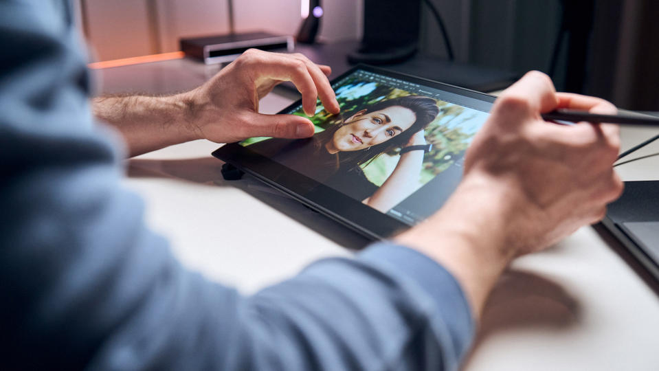 Hands using a Wacom Movink pen tablet on a desk