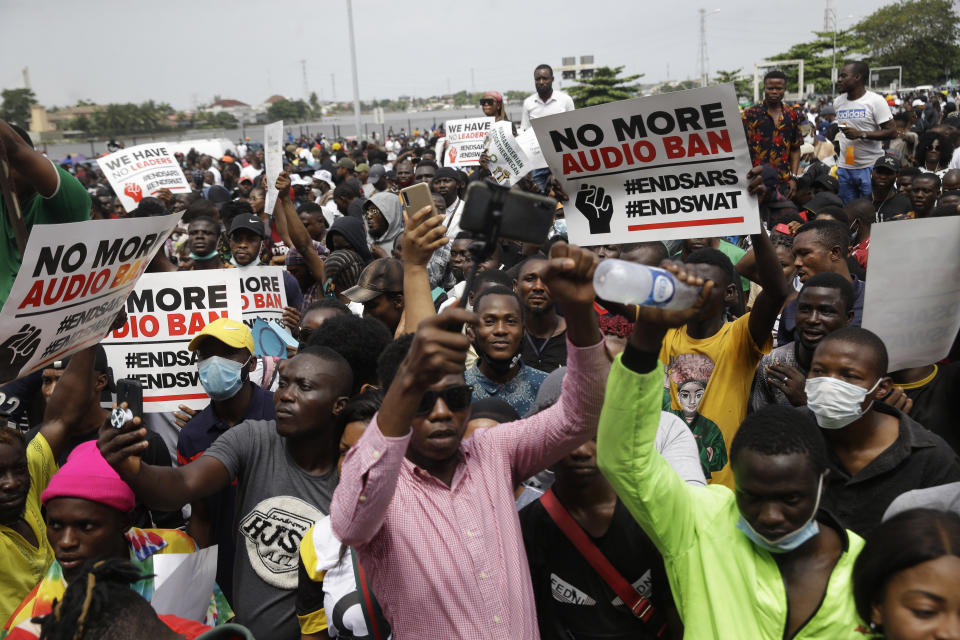 People hold banners as they demonstrate on the street to protest against police brutality in Lagos, Nigeria, Thursday Oct. 15, 2020. Protests against Nigeria's police continued to rock the country for the eighth straight day Thursday as demonstrators marched through the streets of major cities, blocking traffic and disrupting business. (AP Photo/Sunday Alamba)