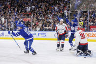 Toronto Maple Leafs right wing Mitchell Marner (16) and Leafs' Michael Bunting (58) celebrate a goal by teammate Morgan Rielly as Washington Capitals goaltender Darcy Kuemper (35) looks on during the second period of an NHL hockey game in Toronto on Sunday, Jan. 29, 2023. (Cole Burston/The Canadian Press via AP)