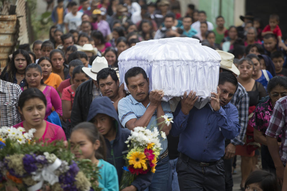 FILE - In this March 12, 2017 file photo, people carry the coffin of 14-year-old Ana Roselia Perez Junay, who died in the fire at Virgen de la Asunción Safe Home, to the cemetery in Zaragoza, Guatemala. The majority of the children at the shelter had committed no crime, but were youths sent there by the courts for various reasons. Most came from families so poor they could not afford the $50 lawyers' fees to get their children out. (AP Photo/Moises Castillo, File)