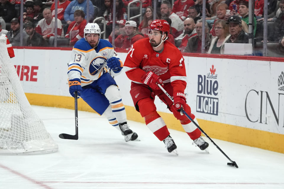 Detroit Red Wings center Dylan Larkin (71) looks to pass as Buffalo Sabres right wing Lukas Rousek (13) defends in the second period of an NHL hockey game Sunday, April 7, 2024, in Detroit. (AP Photo/Paul Sancya)