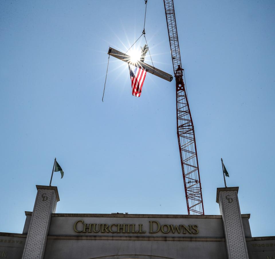 Workers at Churchill Downs lift a beam into place to complete the “Topping Off” ceremony to lower the final piece of steel into place marking a milestone in the completion of a renovated paddock at the track.  Wednesday, September 13, 2023