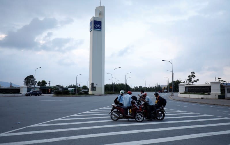 Workers stand in front of Formosa steel mill in Ha Tinh province