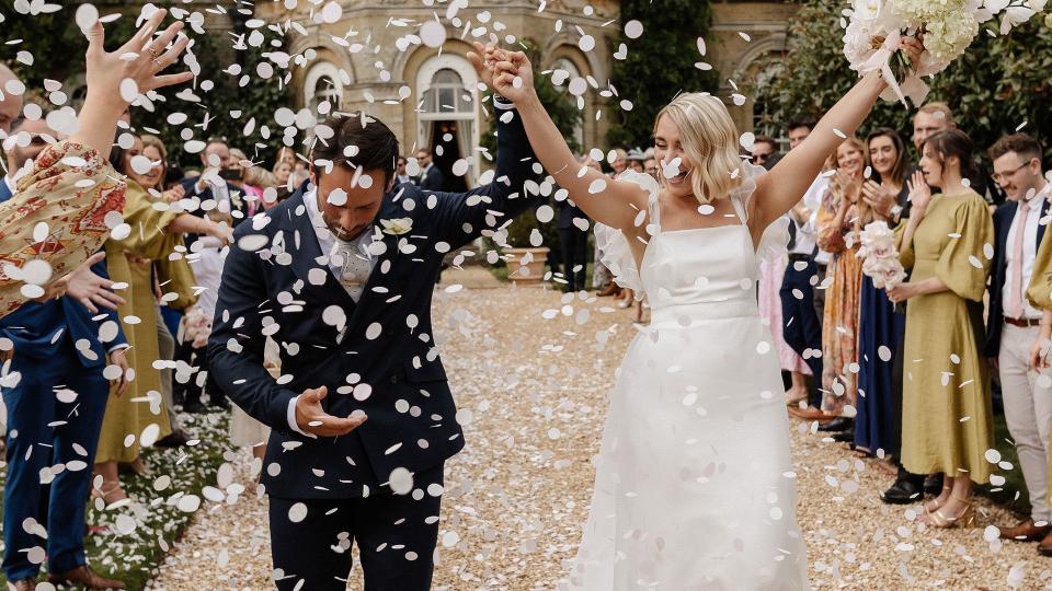 Newlywed couple being showered with confetti outside their wedding venue