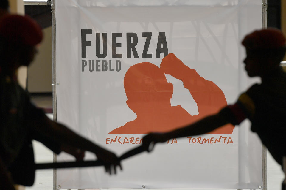 Guards open up an access to the tomb of late Venezuelan President Hugo Chavez during commemorations marking the tenth anniversary of his death, at the Cuartel de la Montaña 4F where his remains are interred in Caracas, Venezuela, Sunday, March 5, 2023. Chavez died on March 5, 2013, after a long battle with cancer and chose current president, Nicolas Maduro, a former bus driver and union leader to be his successor. (AP Photo/Matias Delacroix)