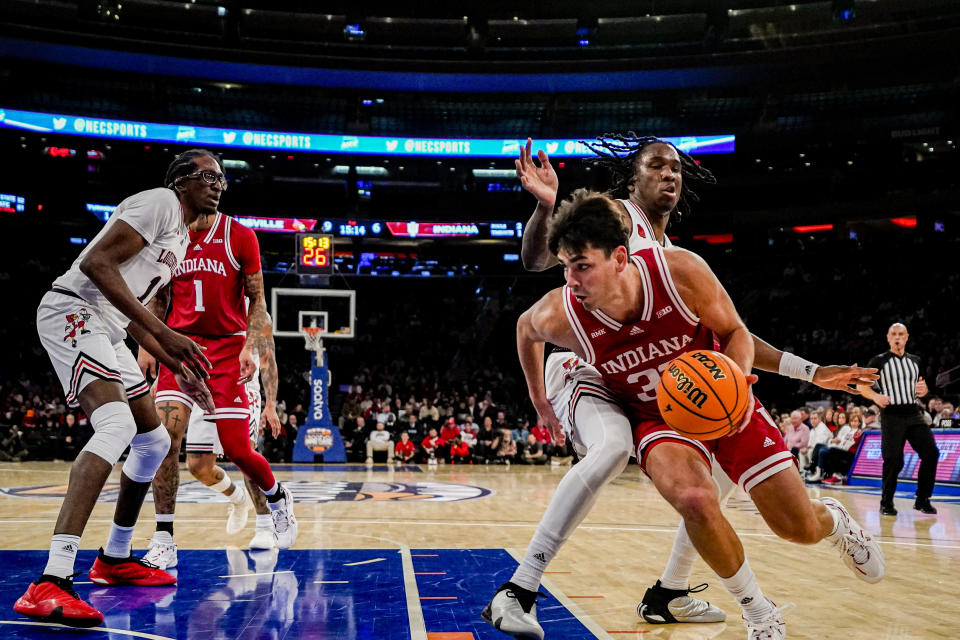 Indiana guard Trey Galloway drives to the basket against Louisville guard Mike James in an NCAA college basketball game in the Empire Classic tournament in New York, Monday, Nov. 20, 2023. (AP Photo/Peter K. Afriyie)