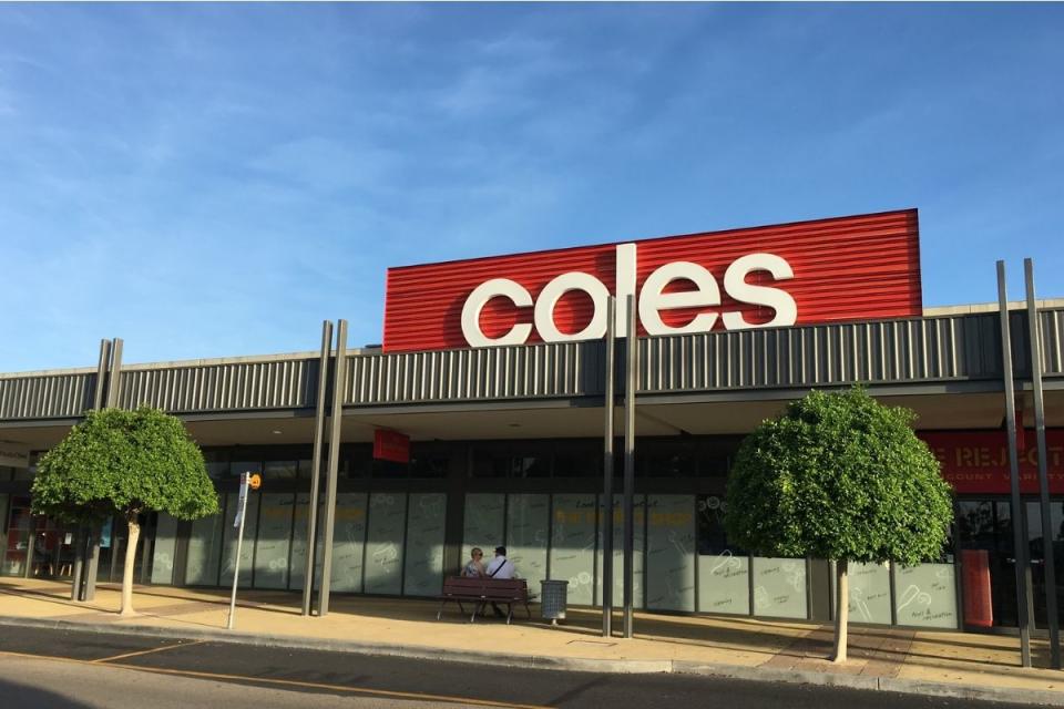 Two people sit outside Coles on a bench. Source: Getty Images