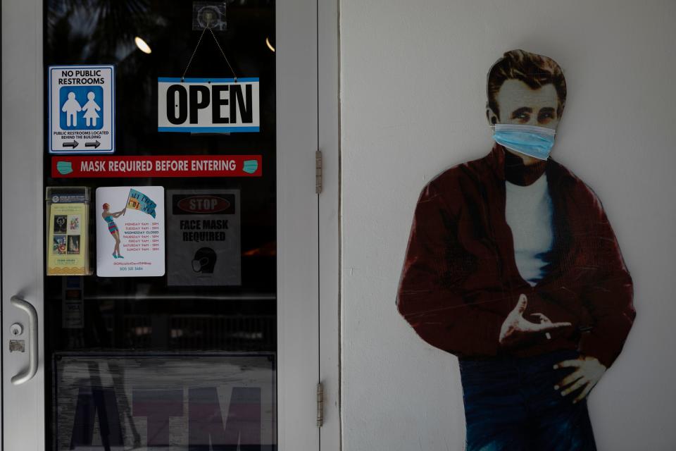 A facemask is seen placed on a mural depicting James Dean at an entrance of a store in Miami Beach, Florida on June 16, 2020. - Florida is reporting record daily totals of new coronavirus cases, but you'd never know it looking at the Sunshine State's increasingly busy beaches and hotels. (Photo by Eva Marie UZCATEGUI / AFP) (Photo by EVA MARIE UZCATEGUI/AFP via Getty Images)