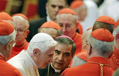 Pope Emeritus Benedict XVI is greeted by Cardinals as he arrives to attend a consistory ceremony in Saint Peter's Basilica at the Vatican February 22, 2014. REUTERS/Max Rossi