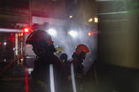 Firefighters battle a fire at a construction site in Hong Kong, Friday, March 3, 2023. Hong Kong firefighters are battling the blaze that broke out at a construction site in the city's popular shopping district. (AP Photo/Louise Delmotte)