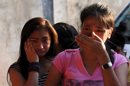 Women weep as they look for missing relatives that were trapped in a fire at a factory in Valenzuela, Metro Manila in the Philippines May 13, 2015. REUTERS/Ezra Acayan