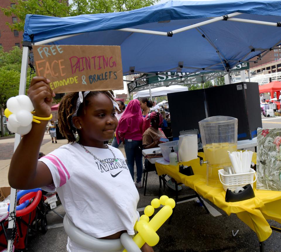 Andee Finley, 9, of Plain Township tries to attract a crowd Friday during EN-RICH-MENT'S third annual African American Arts Festival at Centennial Plaza in Canton.