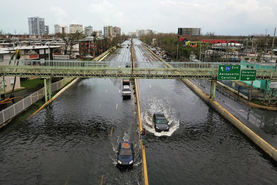 Cars drive through a flooded road in the aftermath of Hurricane Maria in San Juan on Sept.&nbsp;21, 2017. (Photo: RICARDO ARDUENGO via Getty Images)