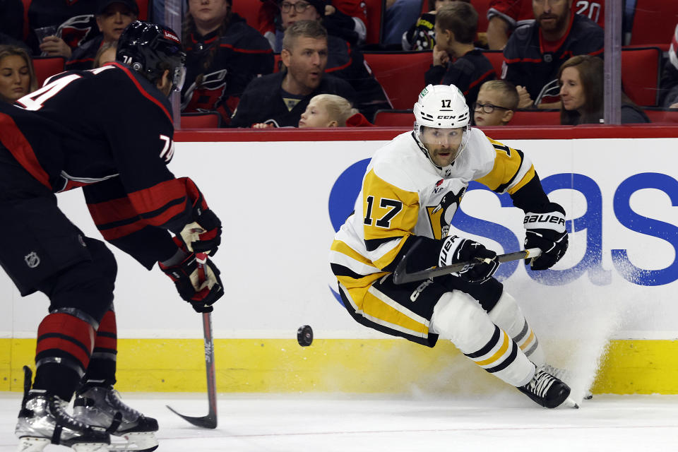 Pittsburgh Penguins' Bryan Rust (17) controls the puck near Carolina Hurricanes' Jaccob Slavin (74) during the first period of an NHL hockey game in Raleigh, N.C., Saturday, Nov. 18, 2023. (AP Photo/Karl B DeBlaker)