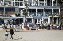 FILE PHOTO: Tourists chill and take drinks in terrace bars in Paguera beach