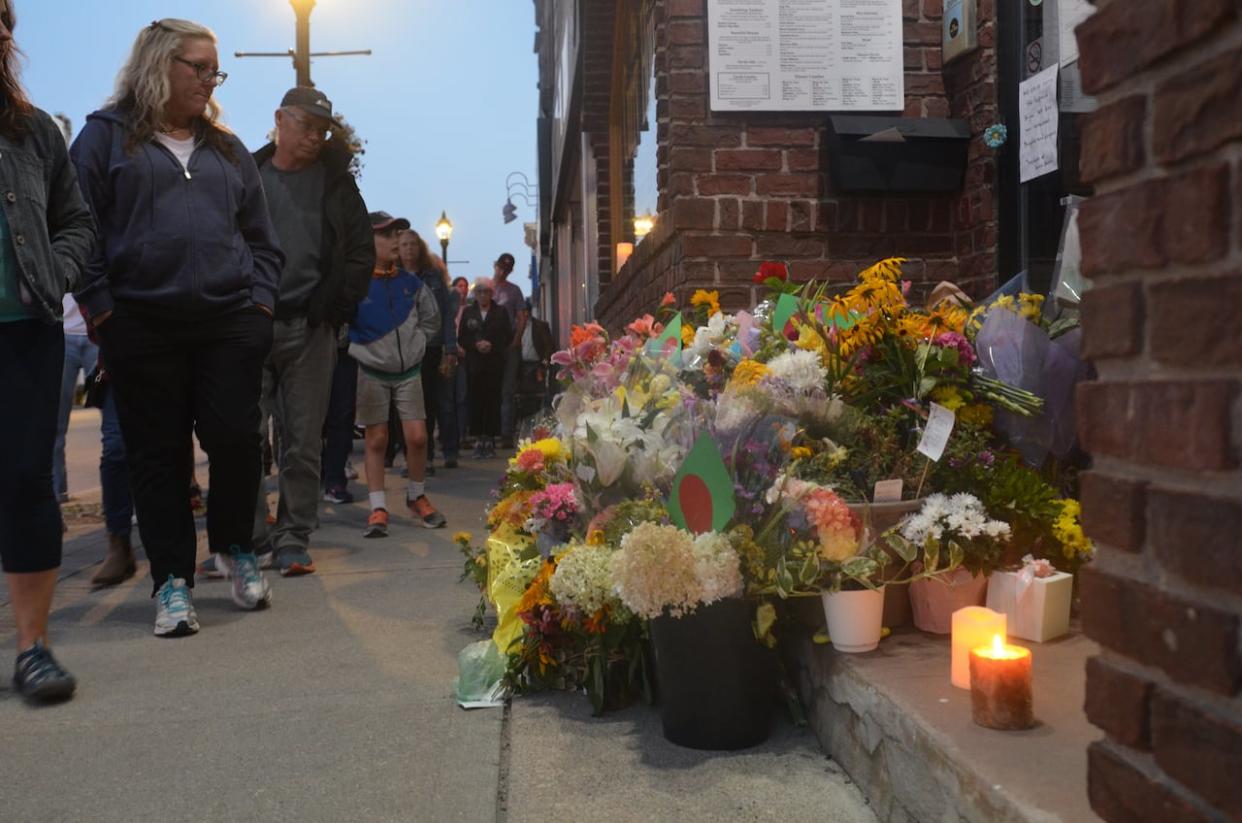 People in Owen Sound pass in front of Sharif Rahman's restaurant Sunday Aug. 28, 2023 following his funeral. Rahman was beaten and later died inside the Curry House.  (Michelle Both / CBC News - image credit)