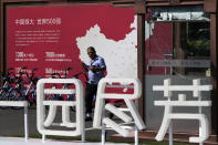 A security guard walks by a map showing Evergrande development projects in China at an Evergrande new housing development in Beijing, Wednesday, Sept. 22, 2021. The Chinese real estate developer whose struggle to avoid defaulting on billions of dollars of debt has rattled global markets announced Wednesday it will make a closely watched interest payment due this week, while the government was silent on whether it might intervene. (AP Photo/Andy Wong)