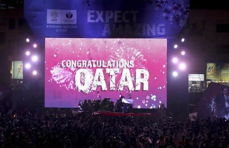 People celebrate in front of a screen that reads "Congratulations Qatar" after FIFA announced that Qatar will be host of the 2022 World Cup in Souq Waqif in Doha, December 2, 2010. REUTERS/Fadi Al-Assaad/Files