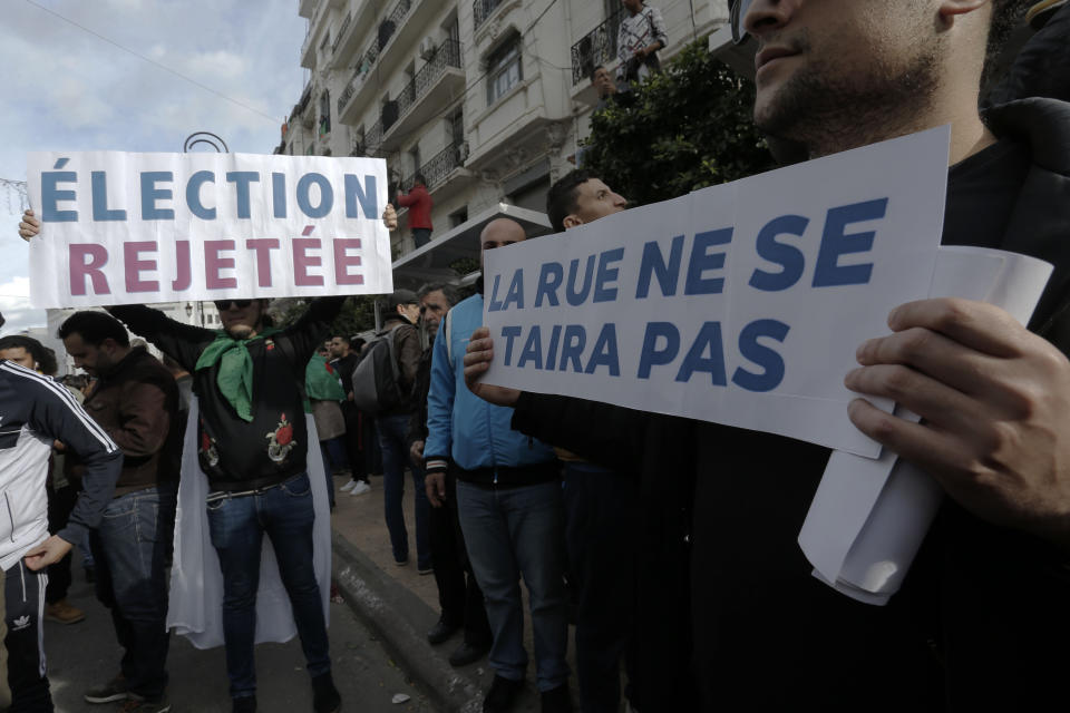 Algerian demonstrators take to the streets in the capital Algiers to reject the presidential elections, in Algeria, Thursday, Dec. 12, 2019. Five candidates have their eyes on becoming the next president of Algeria _ without a leader since April _ in Thursday's contentious election boycotted by a massive pro-democracy movement. Banner in French read "Reject the elections". (AP Photo/Toufik Doudou)