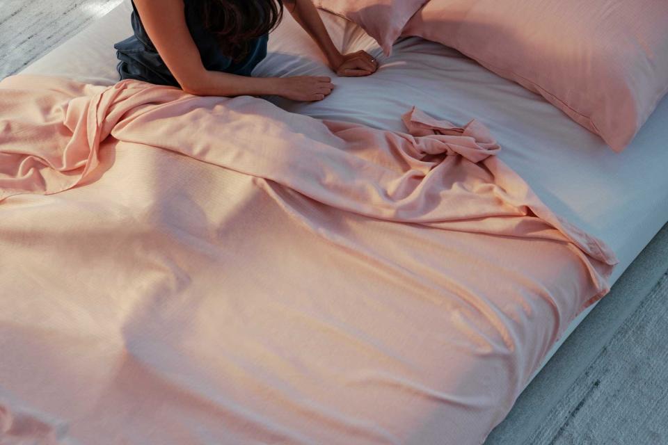 woman sitting in pink sheets