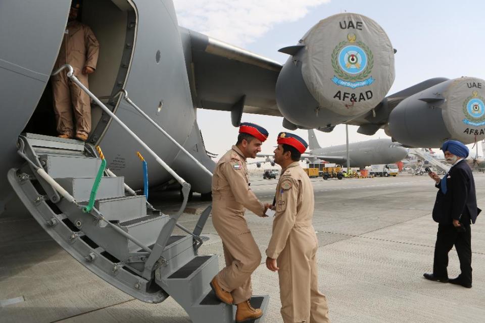 UAE pilots greet each other at the steps of a Boeing C-17 Globemaster III, a large military transport aircraft of the UAE Air forces during the opening day of the Dubai Airshow in Dubai, United Arab Emirates, Sunday Nov. 17, 2013. Boeing Co.'s planned 777X long-haul airliner grabbed the bulk of orders Sunday at the first day of the Dubai Airshow, with at least 225 planes on the books in an eye-popping display of the spending power and aggressive expansion efforts of Gulf carriers. (AP Photo/Kamran Jebreili)