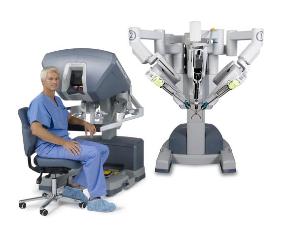 A surgeon sitting in front of a surgeon console as part of a da Vinci system.