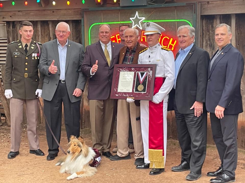 Texas A&M grad Jimmy Tittle, center, receives the Distinguished Alumni Award, with mascot Reveille in attendance. Tittle is a 1949 graduate.